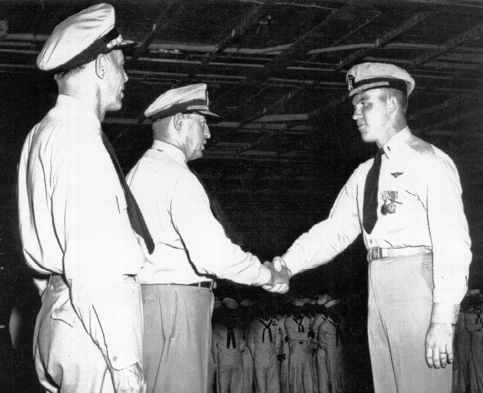 VADM H, J. Clark, Commander Seventh Fleet, congratulates LTjg G. E. R. Kinnear of VA-45 upon being awarded the Air Medal and Commendation Ribbon for outstanding performance of duty while operating against enemy forces in Korea. LTjg Kinnear is embarked aboard the USS Lake Champlain (CVA-39). 1953