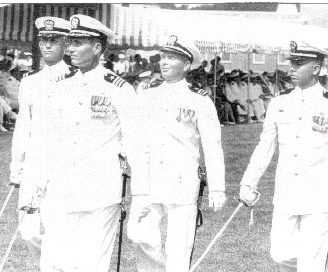 “As Director, O.C.S. Pensacola, Florida, leading units of CNATRA in ‘Pass in Review.’” left to right:  Lt. John Woad, CDR Robert Abels, LCDR “Red” Leftwich, and LT Jim Cook.”