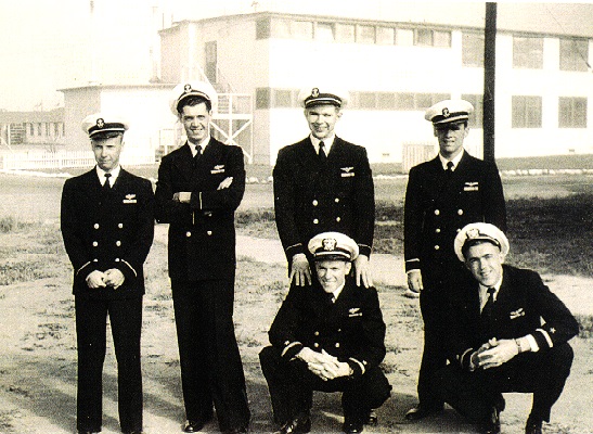 Newly designated aviators at  Fleet Air Electronics Training Unit Pacific  NAAS Ream Field,   San Ysidro, California        standing left to right:  	Rudolph E. (Rudy) Peterson, Jr. 	1/c Mid’n		John W. Reid, Jr.			1/c Mid’n		Ernest H. Schorz			1/c Mid’n  		John R. (Jack) Dewenter, Jr.		1/c Mid’n  	  kneeling left to right:	ENS Ben Baise, USNR			former A/C  	ENS R. A. (Dick) Gosnell, USNR	former A/C    (First duty after receiving wings)