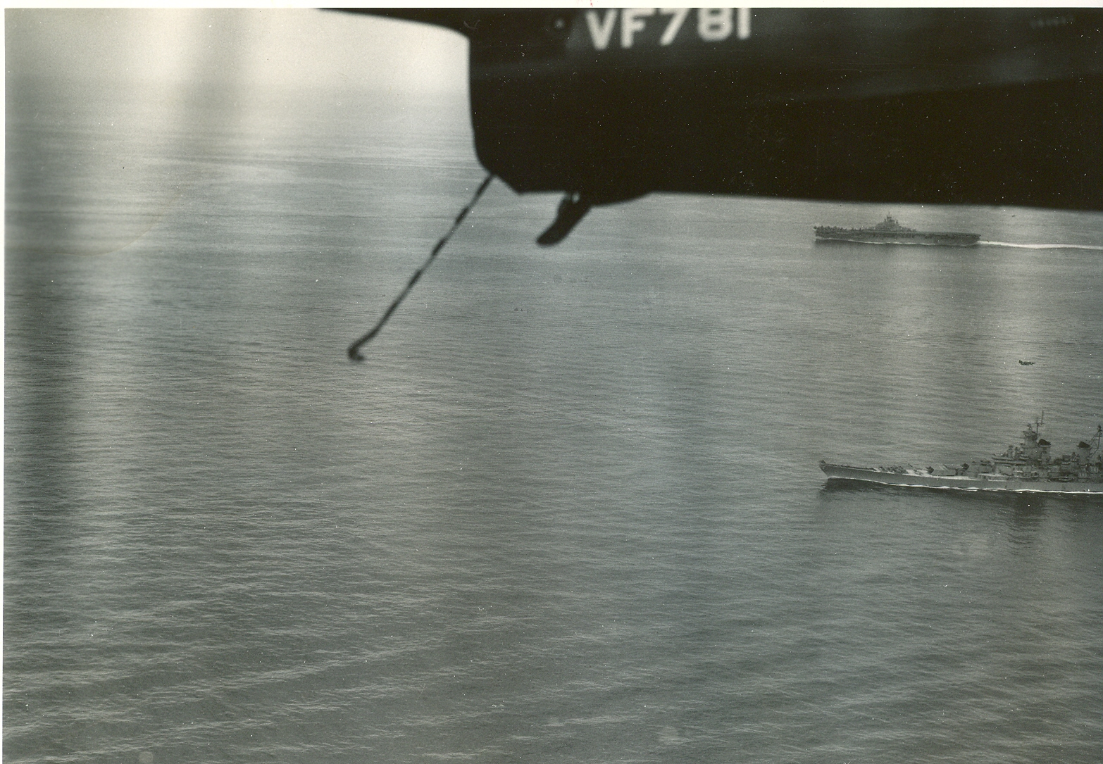 F9F-2B (Lou Ives) overTF-77 for landing. USS Bon Homme Richard (CV-31), USS New Jersey (BB-62). (Note skipper-Collin Oveland-making landing pass and Hoppycopter by BHR fantail).